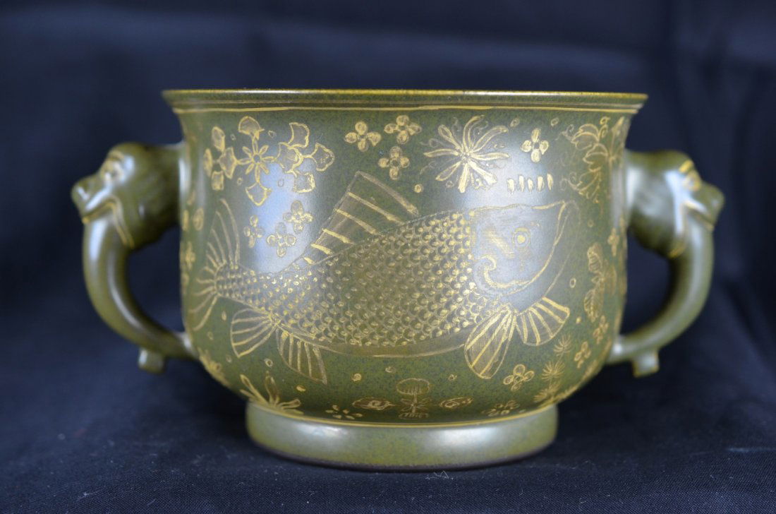 A Gilt and Green-Glazed with Animal head handle Pot: Qianlong Six-Charater Mark in red glaze.This vessel glazed in green on the outside and on the inside, with two animal head handles on either side, is decorated with a gilded fish swimming and two face
