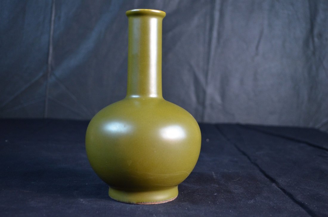 A Chinese Green-Glazed Teadust Bottle Vase: Chinese Qing Dynasty porcelain teadust bottle-shaped vase in olive green. Six -Character Qianlong mark. 7 1/2" x 4 3/4"