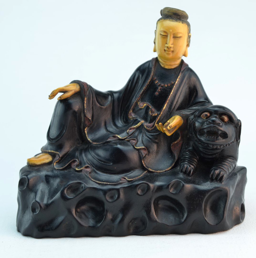 Zitan Wood and Ivory Guan Yin Carving: Zitan wood carving of a seated Guanyin, leaning against a foo dog, accented with carved ivory face, hands, and foot. Chinese characters incised on back. 6" x 6"