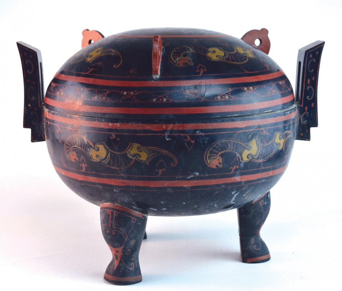 Chinese Three-Footed Laquer Covered Vessel: Chinese three-footed black lacquered vessel with two rectangular cut-out handles, the lid and body with gilded and red painted designs, Han Dynasty. Unmarked. 10 1/2" x 13"