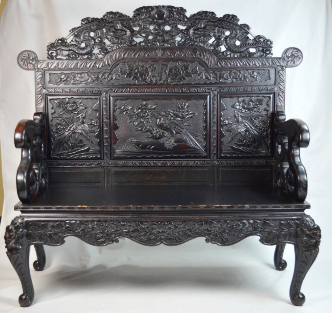 CHINESE Hardwood bench with ornate carvings: CHINESE Hardwood bench with ornate carvings of panels of birds, flowers, topped by dragons, the feet formed by foo dogs or masks. 47'' x 50'' x 22''