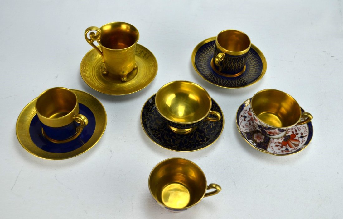 PORCELAIN Five gilded cup and saucer sets: PORCELAIN Five gilded cup and saucer sets; Noritake in copper red and cobalt blue with two cups and one saucer, two PT Germany, Johann Haviland with flowers, and one DW Germany. Tallest: 2 3/4''