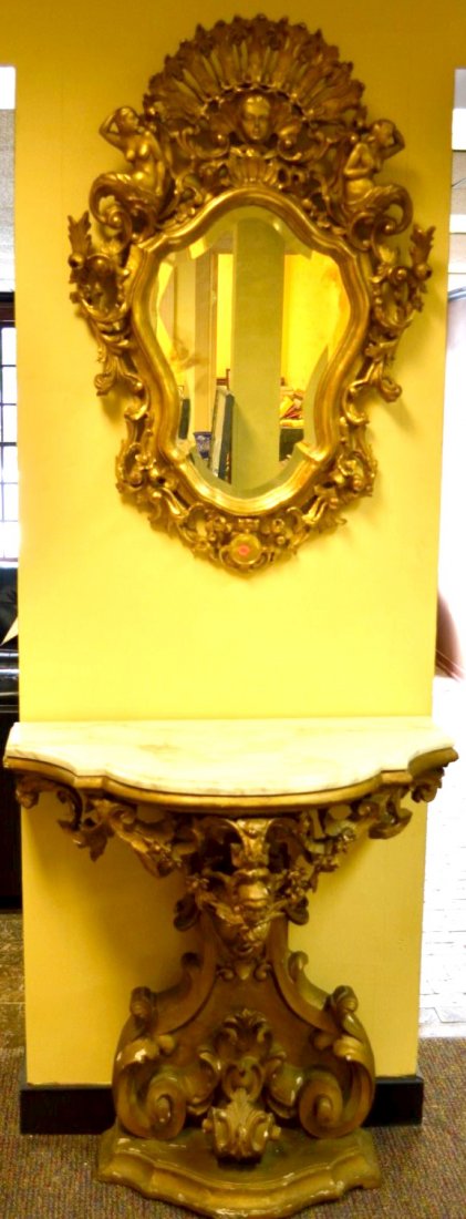 MIRROR & CONSOLE TABLE Both of gold lacquered wood: MIRROR & CONSOLE TABLE Both of gold lacquered wood, the ornately carved mirror with flowers, nude figures, and scrollwork, together with a console table topped with Italian marble over the carved wood