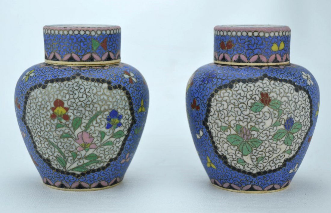 JAPANESE PORCELAIN Pair of covered jars: JAPANESE PORCELAIN Pair of covered jars with cloisonne-like design of medallions of flowers, against a periwinkle ground, the outer lid with fine mosaic pattern, covering a small inner lid. Copper red