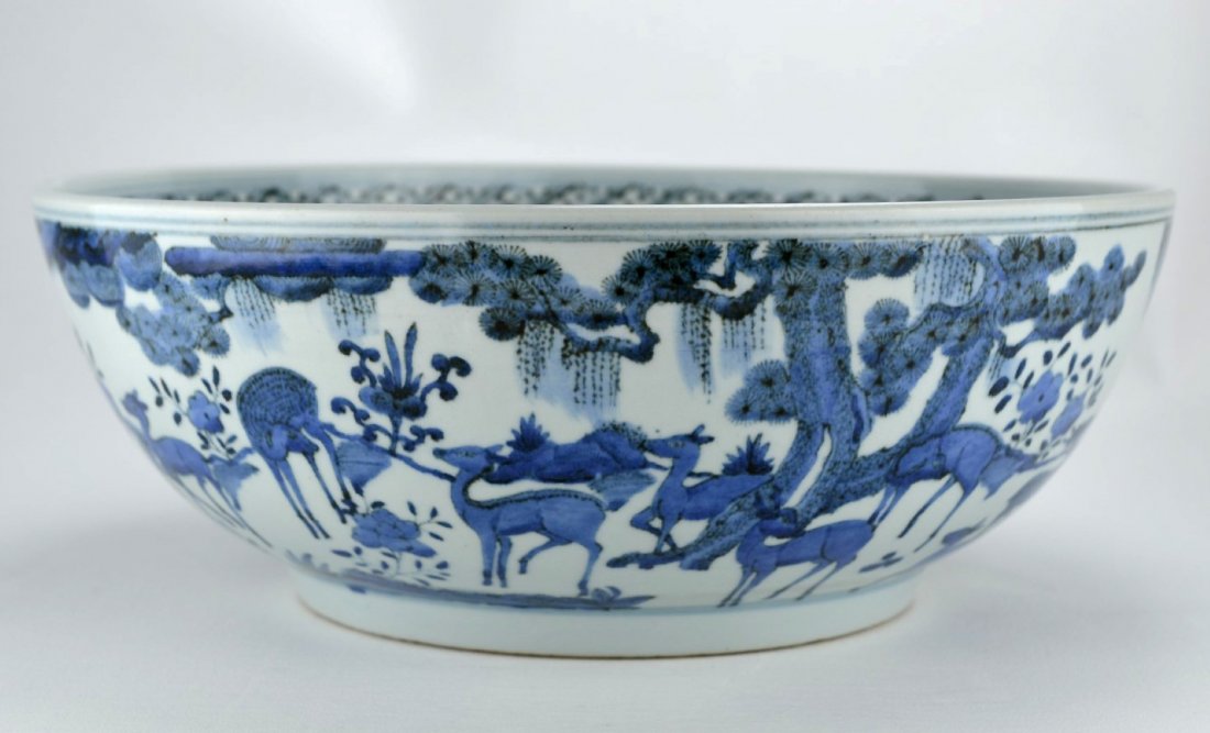 19th C Chinese Massive blue and white bowl: CHINESE PORCELAIN Massive blue and white bowl painted with deer in a field on both interior and exterior, the rim with banded geometric design, 19th century. 5 3/4'' x 15'' dia.