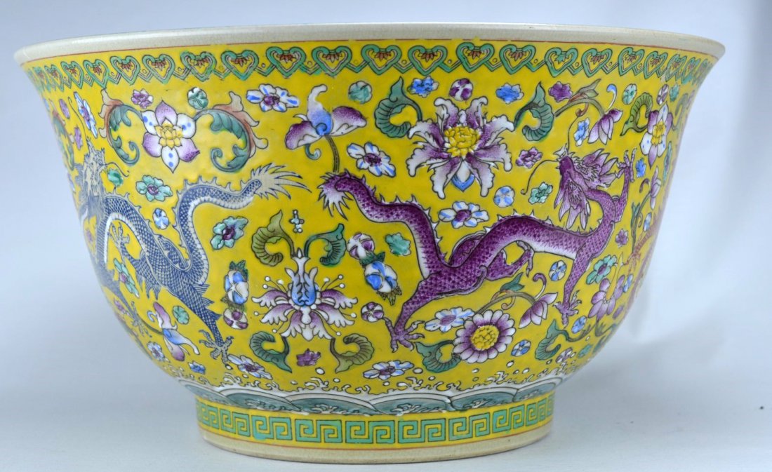 19th C Chinese Massive bowl with dragon: CHINESE PORCELAIN Massive bowl with elaborate dragon and floral pattern against bright yellow ground, the base with banded Greek Key motif, the interior in robins egg blue glaze, 19th century. Cracks