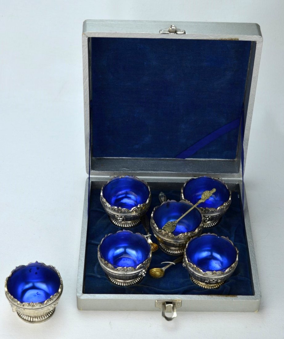 SILVERPLATE Boxed Set of Six Caviar Dishes and Spoons: SILVERPLATE Boxed set of six cobalt glass-lined caviar dishes or egg cups, the silverplated, footed vessel with lion heads and scrolled design, together with four shell-shaped small spoons. Broken gla