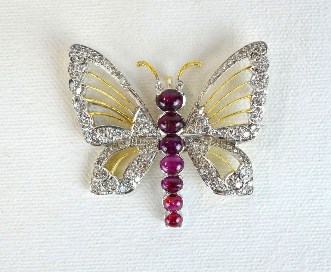 Diamond and Ruby Butterfly Pin: Exquisite diamond and ruby butterfly pin set on 18kt gold, the body with seven cabochon rubies, the wings outlined with 104 small diamonds, graded, VS clarity, F color, veins in wings and antennae for