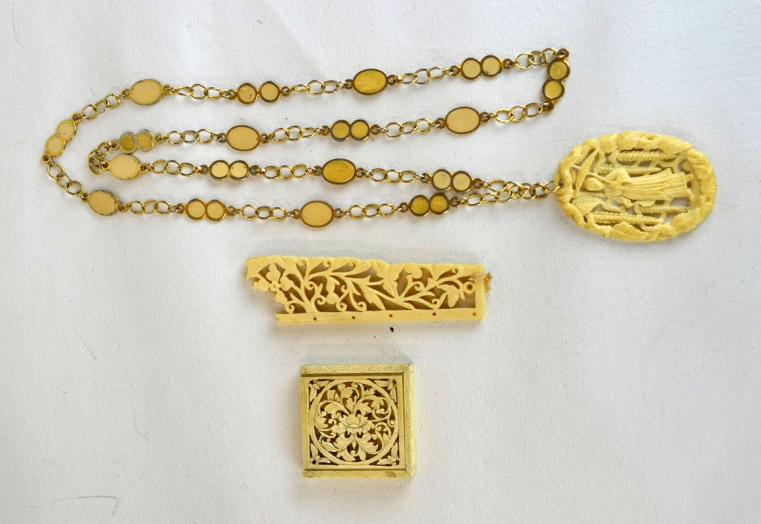 Four Antique Carved Ivory or Bone Pieces: Four antique carved ivory or bone pieces including a large pendant with figure holding an umbrella in foliate ''frame'', suspended from a metal and stone chain, a puzzle box, and two carved panels (br
