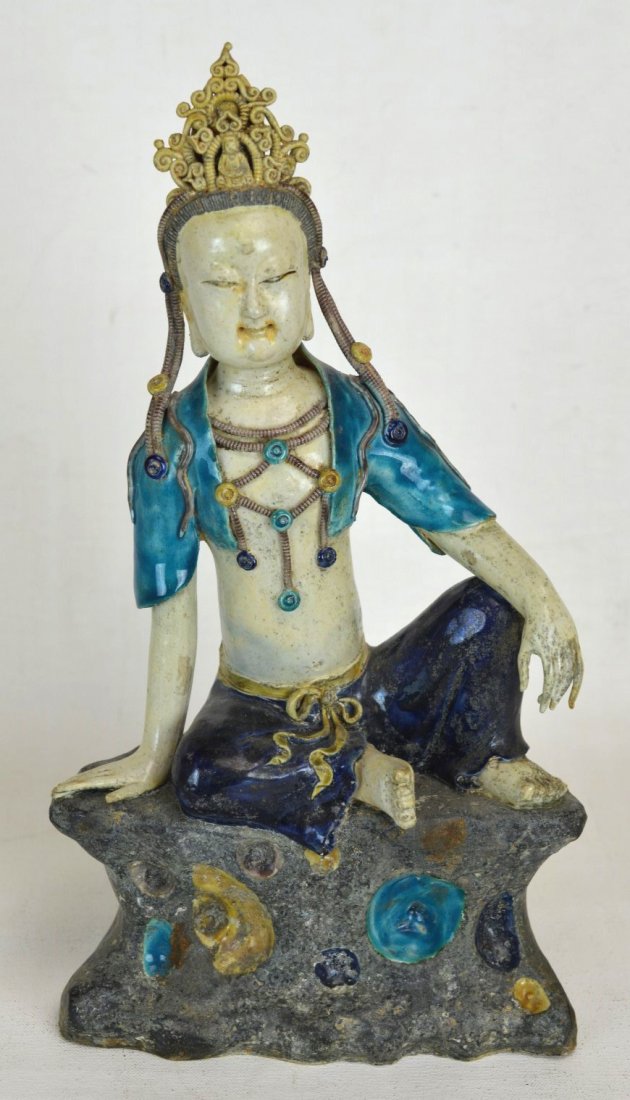 Highly Decorated 15/16th c. Chinese Seated Guan Yi: Highly decorated Guan Yin figure seated atop stone. Figure wears turquoise painted vest and dark blue drawstring pants; also includes intricate crown. 15/16th c. Height - 13 1/4''