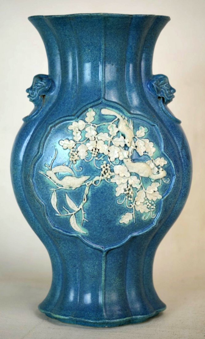 19th C. Chinese Flattened Lotus Vase: A Chinese jasperware flattened lotus flared vase with handle decoration. Two framed scenes carved in high relief; one of a coastal landscape and the other of three squirrels in foliage. 19th century.