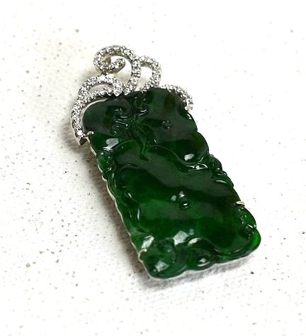 Jadeite and Diamond Pendant: Rectangle shaped Jadeite Pendant carved with a floral pattern on the front face. The Jadeite is set with an 18K white gold backing carved with a floral design. Intricate bail set with diamonds. Measur