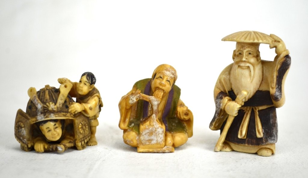 Three Japanese Antique Ivory Netsuke Figures: Three netsukes; two ivory figures of men and one of two boys playing with a samurai hat. All marked. 19th century. Dimensions: Biggest height - 1 7/8" Smallest height - 1 3/8" 19th century