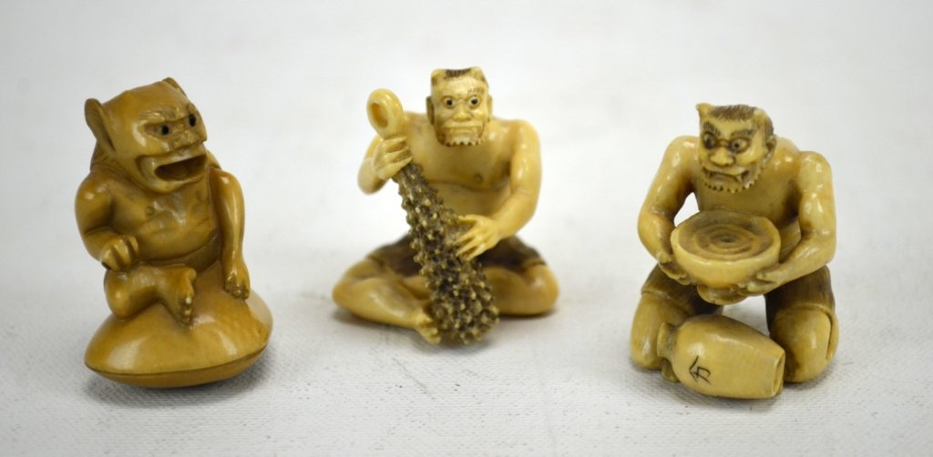 Three Japanese Antique Ivory Netsukes of Oni: Three antique ivory netsukes of oni; one with a club, one with a rice bowl, and one on a clam shell. All marked. 19th century. Dimensions: Height of all approximately 1 5/8"