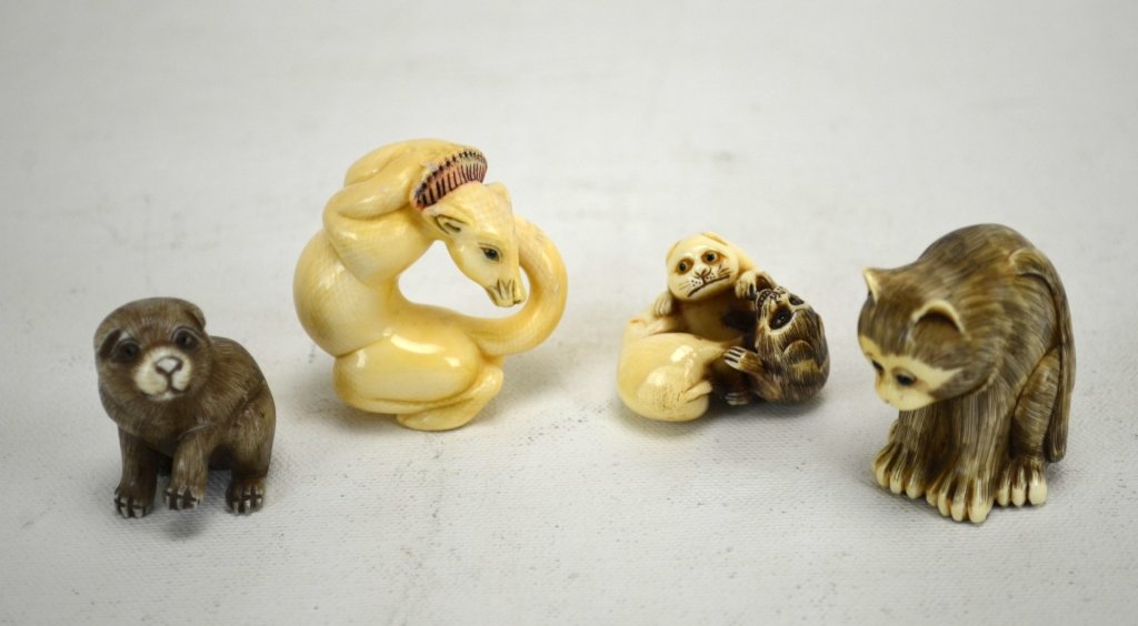 Four Japanese Antique Ivory Animal Netsukes: Four antique ivory netsukes carved into animals; a seated pug, a ball of pups, seated cat, and a curled fox. All marked. 19th century. Dimensions: Biggest height - 1 3/4" Smallest height - 1 1/8"