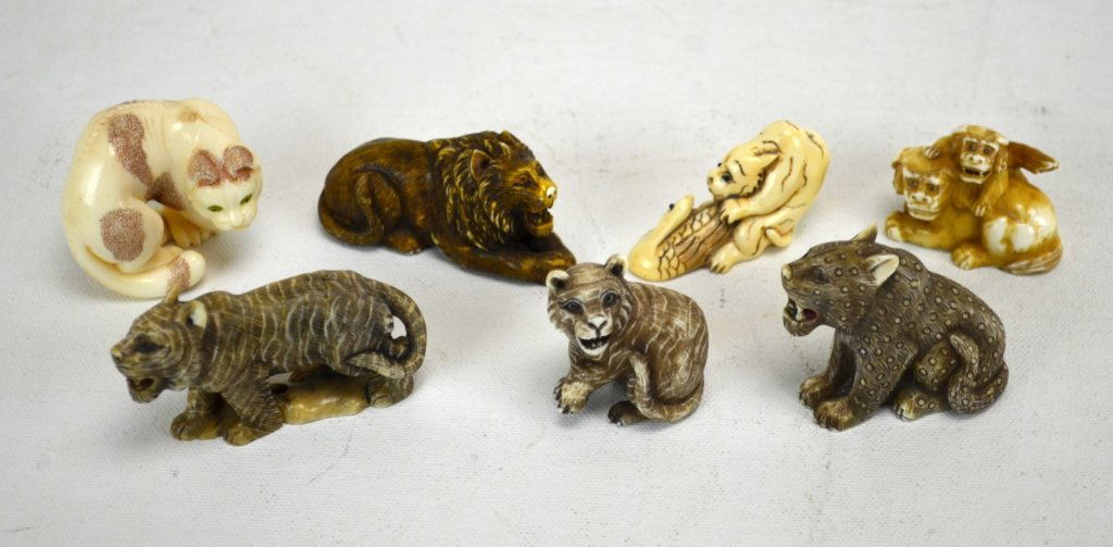 Seven Japanese Antique Ivory Tiger Netsukes: Seven antique ivory tiger netsukes; a seated tiger and a curled tiger (unmarked). A seated tiger, tiger mating with swan, lion and cub, a standing tiger, and a seated lion (marked). 19th century. Dime