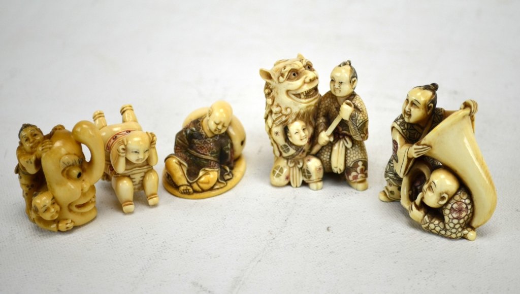 Five Japanese Antique Ivory Netsukes: Five antique ivory netsukes; two men blowing a large horn, a man with youth inside a mask, two boys playing with a mask, "Upside Down Boys," and a boy sleeping on a peach. All marked. 19th century. Di