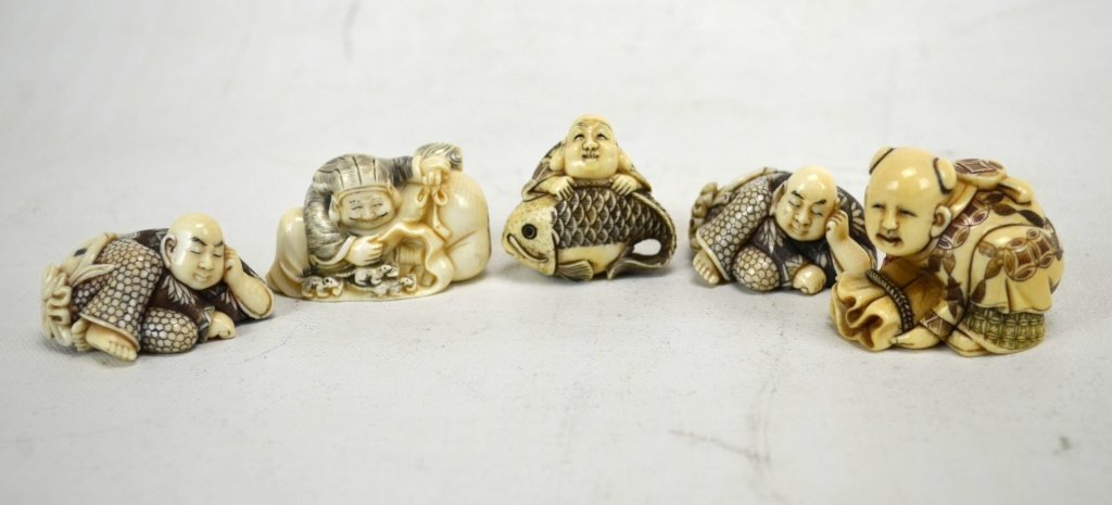 Five Japanese Antique Ivory Netsukes: Five antique ivory netsukes; two of Buddha sleeping on magic bag, a poylchrome boy sleeping on magic bag, a polychrome Hoti sleeping on a magic bag, and a polychrome Hoti on a carp. All marked. 19th c