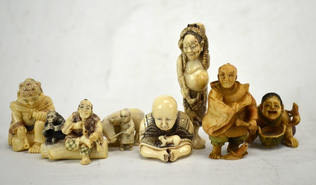 Seven Antique Ivory Netsukes of Men with Animals: Seven Japanese antique ivory netsukes of men with animals; a man with fish, a man with an octopus on his head, a man smoking a pipe with monkey on his back, a man with a cow, a man with a bowl and a m