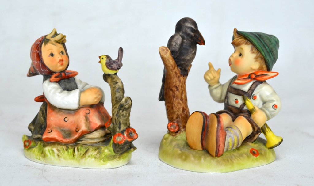 Two M.J. Hummel Goebel Figurines: Two Goebel figurinese by M.J. Hummel. "Sing Along" of boy singing with a crow. "In Tune" of girl singing with small purple and yellow bird. Height of tallest - 4 1/8"