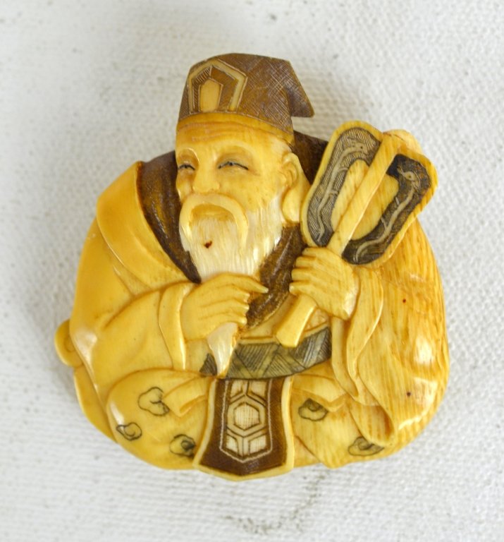 Signed Japanese Ivory Carving Pin: A small ivory carving of a seated man stroking his beard and holding a fan. Signed with two characters on back. Measures 2" x 2 3/8" Early 20th Century