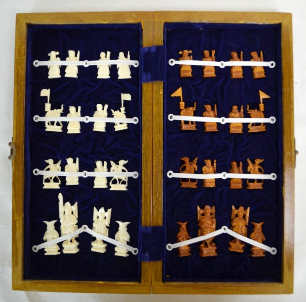 Chinese Bone Chess Set: A Chinese bone chess set with a folding wooden box that serves as the board. The pieces are in excellent condition; one set not dyed and the other is tea dyed. Open measures 14'' x 14'' and closed mea