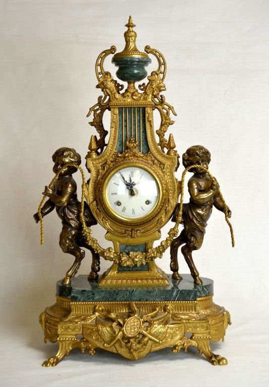 Franz Hermle Brass & Green Marble Mantel Clock: A Franz Hermle brass and green marble mantel clock. Dial features roman numerals and is marked "Imperial". Clock features two young satyrs on the sides and rooster heads at the top. Back of clock is m