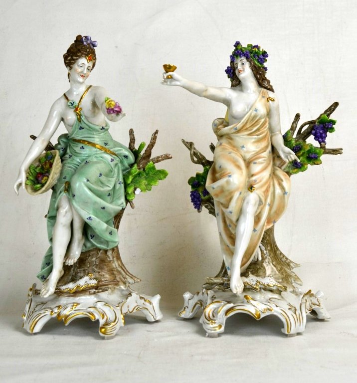Two German Kister Porcelain Figures: Two early 20th century german porcelain figures of women resting on tree trunks. Porzellanmanufaktur A.W.F. Kister G.m.b.H. mark and "Germany" on back of trunk. Height of tallest - 13 1/2"