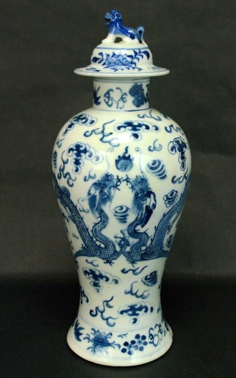 Chinese Blue and White Lidded Baluster Vase: A Chinese blue & white lidded baluster Vase decorated with two dragons in the clouds, chasing a flaming pearl. The rimmed lid as a foo dog handle on top. Four character underglaze blue mark on bottom.