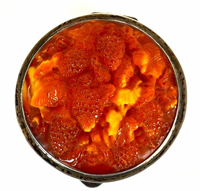 German Silver Box with Carved Amber Lid: German silver round box, the lid set with circular amber carved with berries and leaves. Impressed marks on bottom. 1 1/2" x 2 1/2" dia.