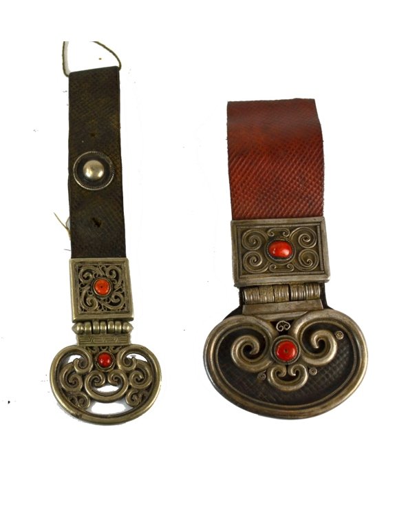 Two Mongolian Silver & Coral Buckles: Two Mongolian silver buckles on leather straps, each accented with two coral cabochons. Impressed seal mark to back of one. 8 1/4" and 6 1/2" each.