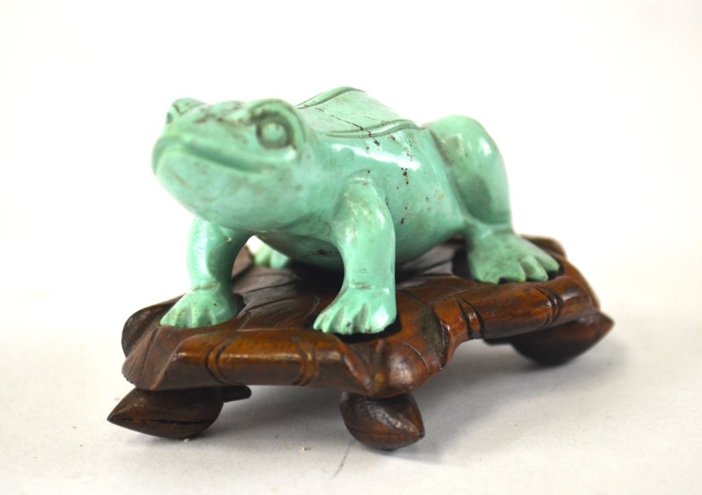 Chinese Carved Turquoise of Frog with Wood Base: Chinese turquoise carving of a frog sitting on a lotus leaf wood base. 1 1/4" x 2"