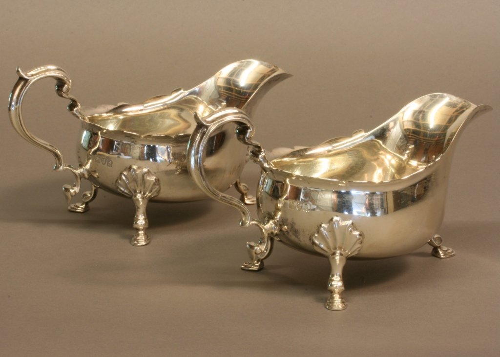 A Pair of Late Victorian Sauce Boats. Thomas Bradbury,: A Pair of Late Victorian Sauce Boats. Thomas Bradbury, London 1899. In typical Georgian style. With waved everted rim, flying scroll handle and hoof feet. 17cm long. 9.5cm high. 498.8 grams. 15.9 ounc