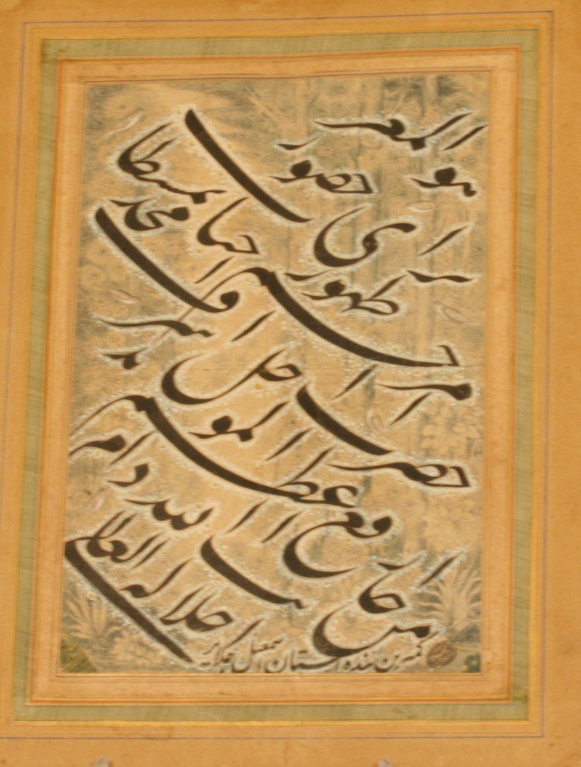 An Islamic Calligraphic Panel. Signed Ismail IL Jalayir: Gouche on buff paper, the panel with a bold nasta'liq verse written in black over a white floral background with a dense woodland with birds and ground foliage. Signed at the bottom kamitarin bandah-y