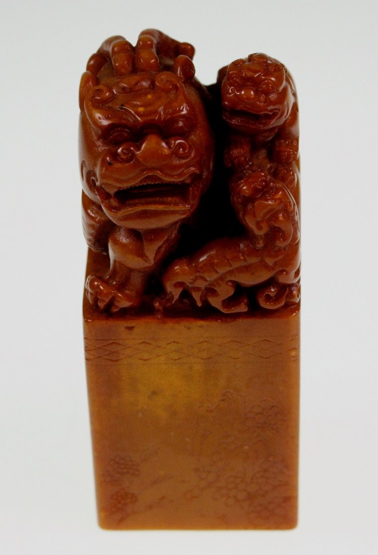 A Chinese Soapstone: A Chinese Soapstone Seal. Cinnamon in colour. Circa 1900. Carved with a Temple Lion or Fo Dog. 9.5 cm high.