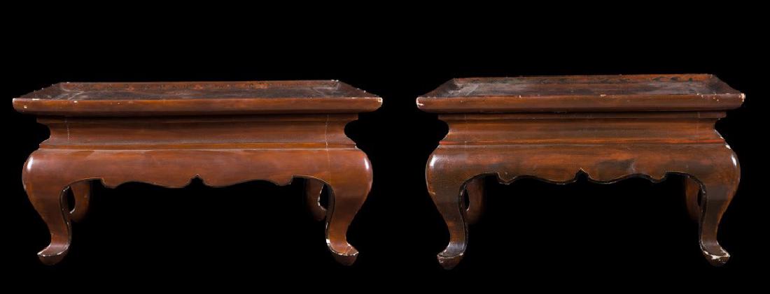 A pair of lacquered wood tea tables with figures of: cm 38x50,5x68,5