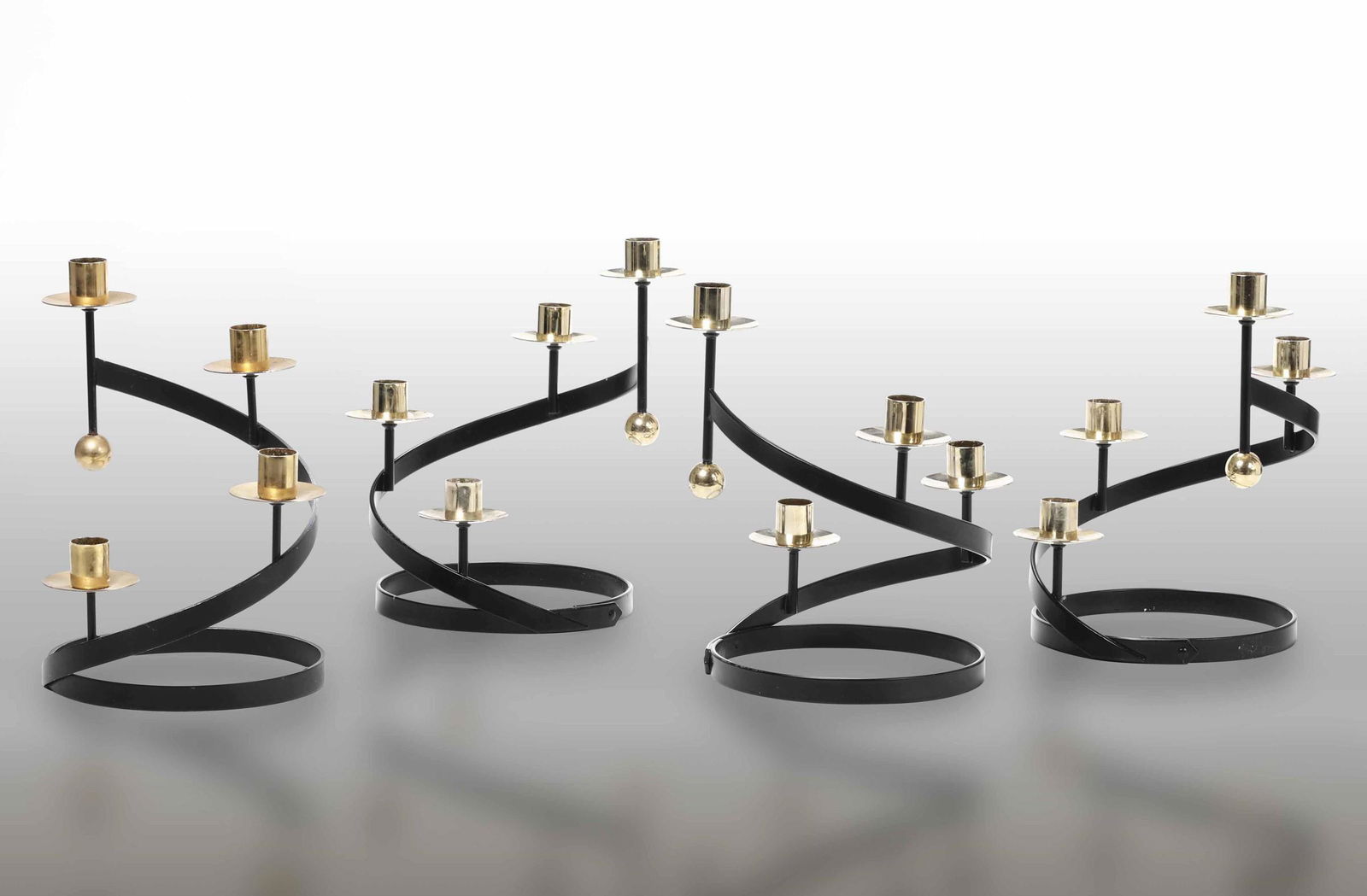 Gunnar Ander (attribuzione),: Quattro candelabri con struttura in ottone e metallo laccato. Prod. Svezia, 1960 ca. cm 25x16