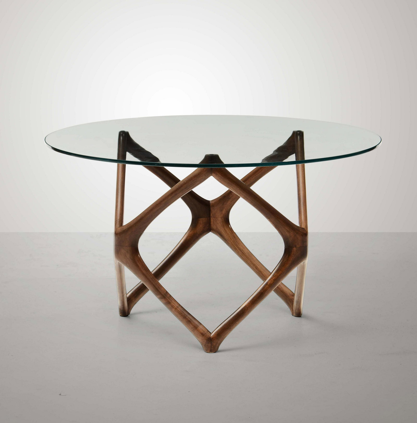 Pierluigi Giordani (attribuito),: Tavolo basso con struttura in legno scolpito e piano in cristallo molato. Prod. Italia, 1950 ca. cm 46x81