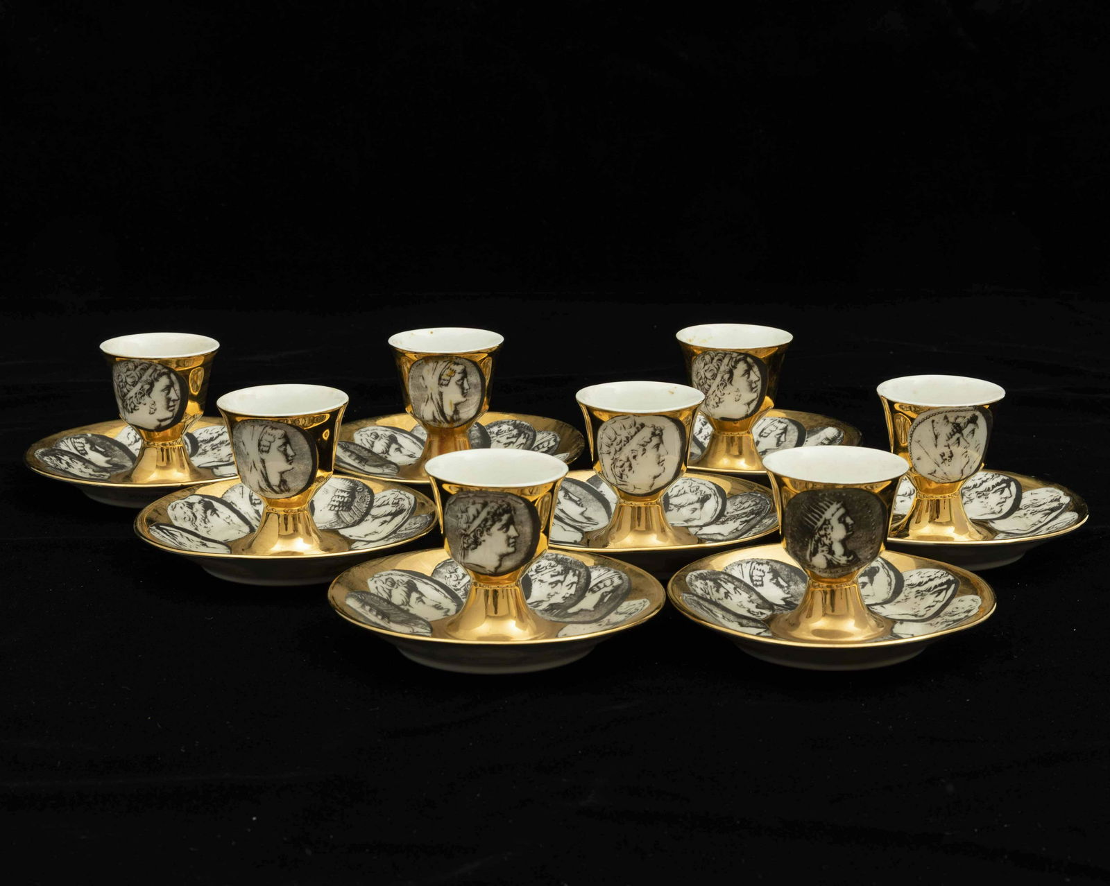Fornasetti Piero, Eight porcelain egg cups, Milan, 1950 ca.: Otto portauovo in porcellana con decoro di medaglioni.
