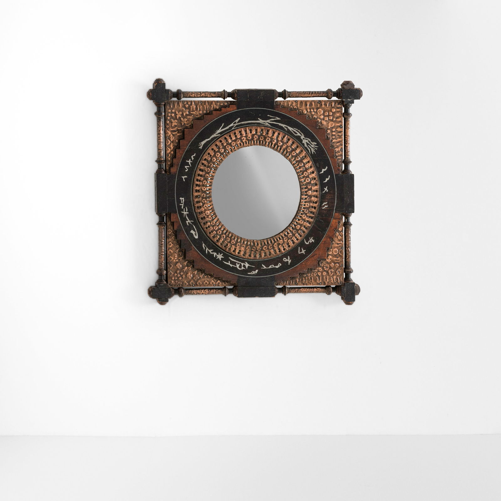 Carlo Bugatti Specchio a parete: Struttura in legno e legno ebanizzato con rivestimenti in rame sbalzato, intarsi in metallo e cristallo specchiato.Prod. Italia, 1900 ca.