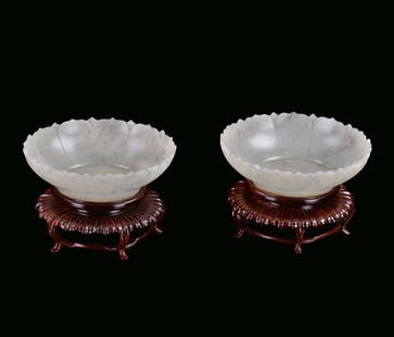 Pair of small white jade Mogul cups with shaped ri: Pair of small white jade Mogul cups with shaped rim China, 20th century Carved wooden base, diameter cm 14,5