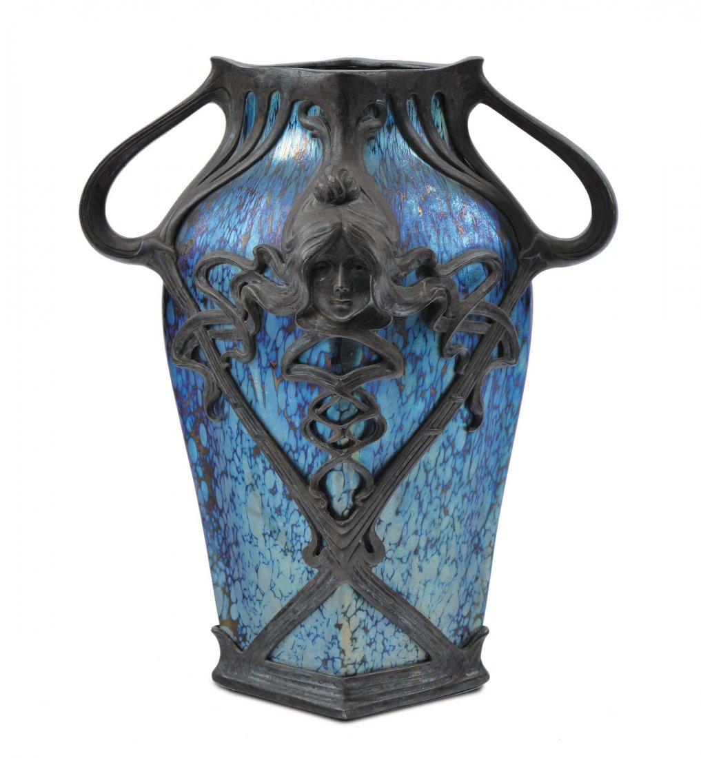 Loetz - Austria Vaso in vetro Cobalto Papillon: vetro violetto, turchese e argenteo con forti iridescenze. Bellissima montatura coeva in metallo argentato a colpi di rusta e con due volti muliebri, 1900 circa. Altezza cm 27 Cfr.: H. Cantz, J. Mergl