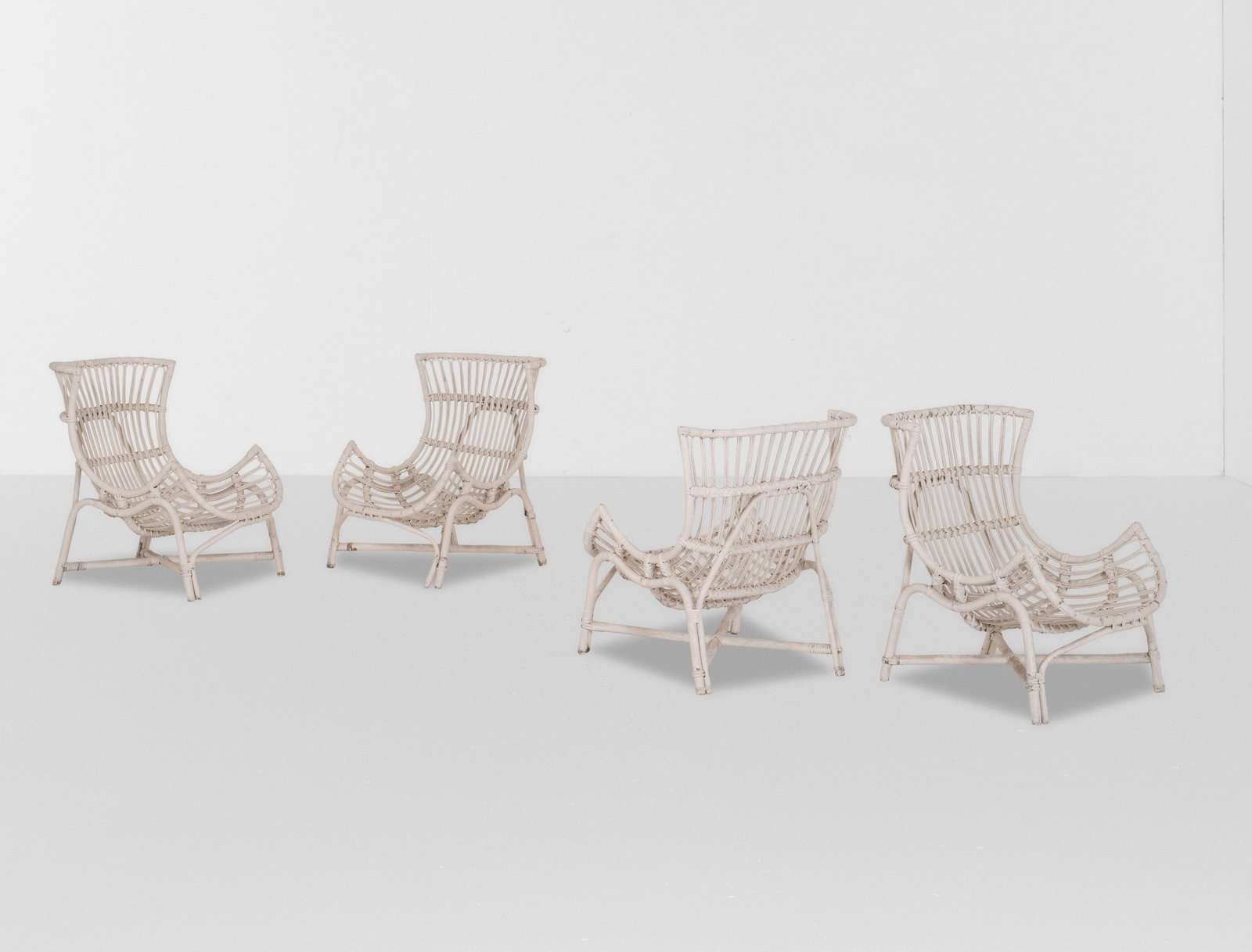 Quattro poltrone: Struttura in bambù e giunco laccato. Cuscini in tessuto.Prod. Italia, 1950 ca.