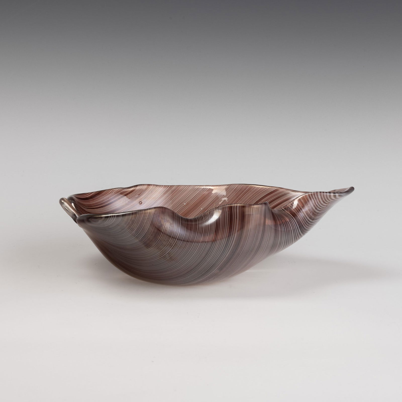 Tyra Lundgren 1897-1979 Venini, Murano, 1936 ca.: Leaf-shaped ornament with wavy rim in half-filigree sommerso glass. Surface iridescent throughout.Acid-etched signature, Venini Murano. Cm 24x15