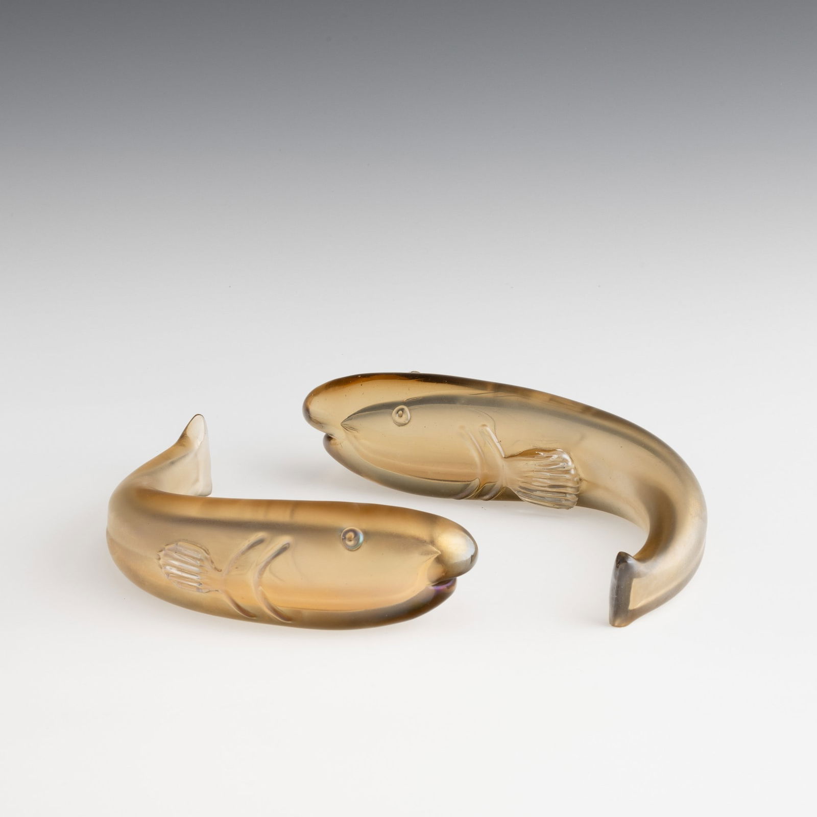 Tyra Lundgren 1897-1979 Venini, Murano, 1936 ca.: Pair of fish with curved body in straw-colour sommerso glass.Iridescent surface.Acid-etched signature, Venini Murano. M. Barovier, C. Sonego, a cura di, Paolo Venini e la sua fornace, Catalogo della m