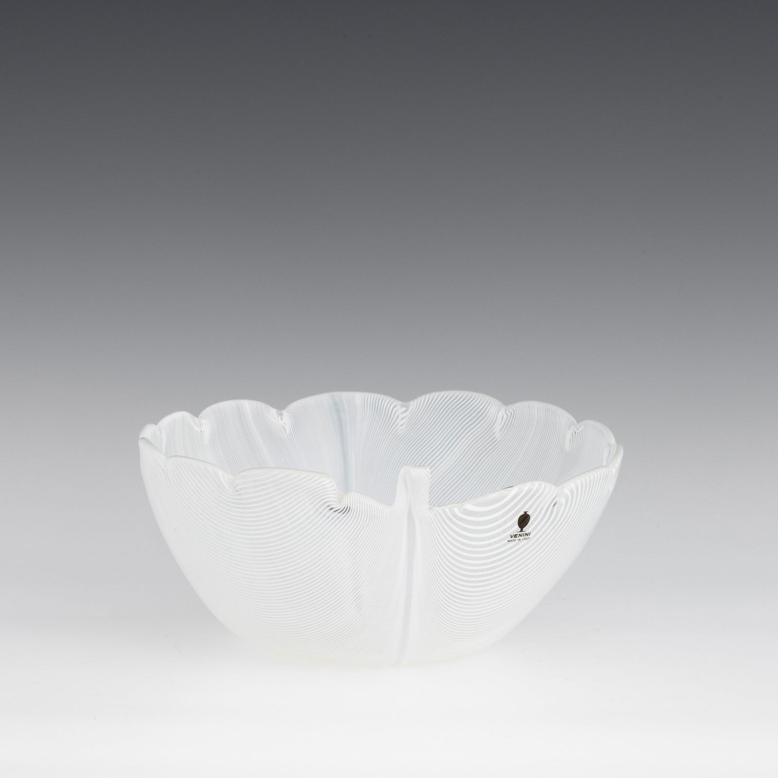 Tyra Lundgren 1897-1979 Venini, Murano, 1980.: Leaf-shaped ornament in blown glass with 'lattimo' (milky) half-filigree decoration.Etched date and signature, Venini Italia 80, and old label. Altezza cm 8,5 cm 19x21