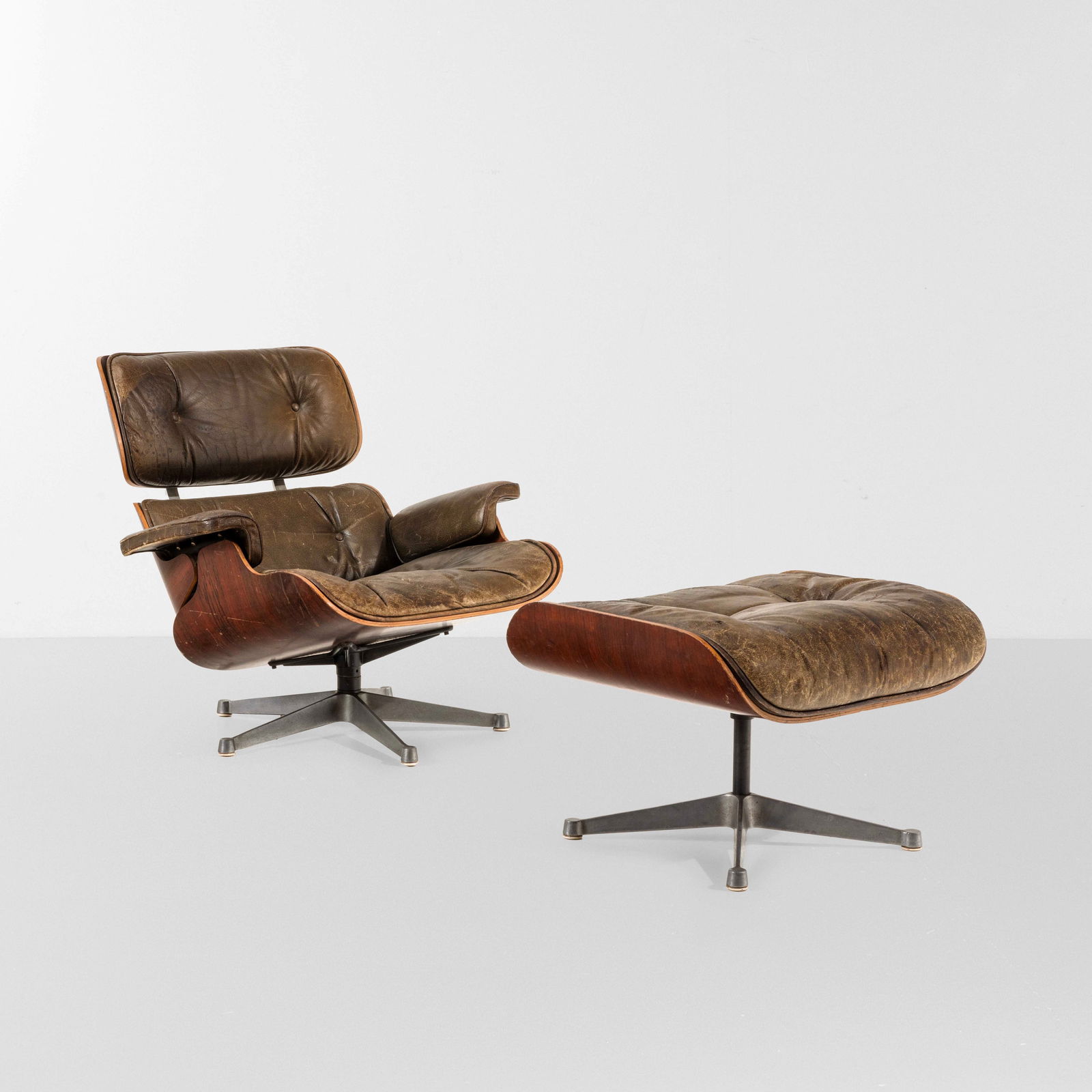Charles & Ray Eames Lounge chair con ottomana mod. 670 e 671: Struttura in legno compensato curvato sagomato e impiallacciato. Sostegni in alluminio e seduta con rivestimenti in pelle.Prod. ICF, Italia, 1960 ca.cm 83x75x76 (poltrona)@@@ 65,5x55x43 (ottomana) Eam