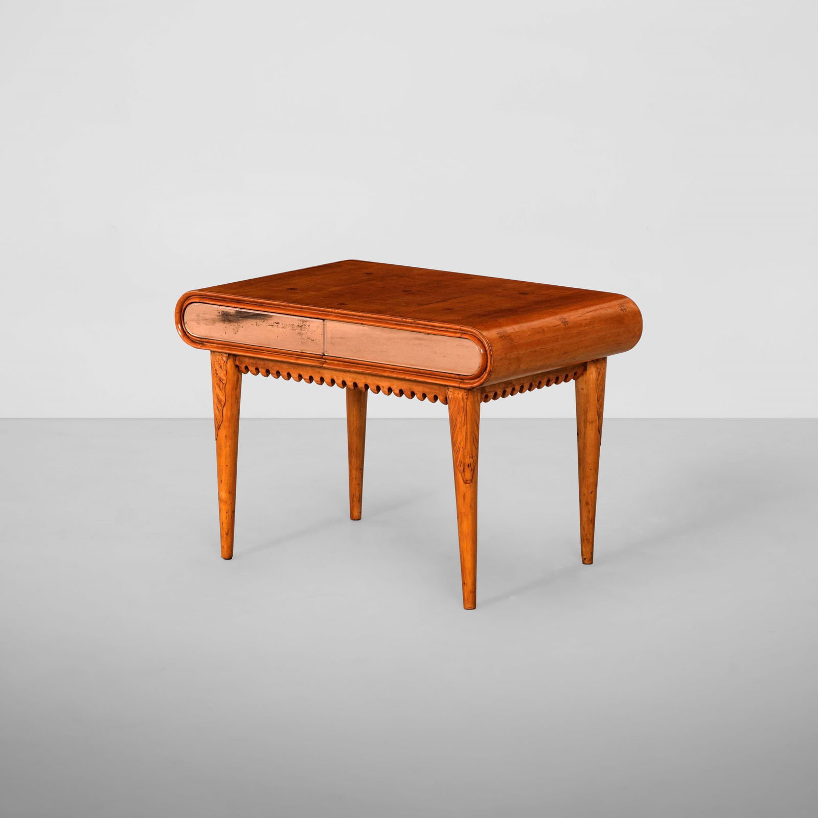 Paolo Buffa Tavolo basso: Struttura in legno e legno scolpito con piano a decoro in legno impiallacciato. Cassetti rivestiti di cristallo specchiato e colorato. Prod. Italia, 1940 ca.