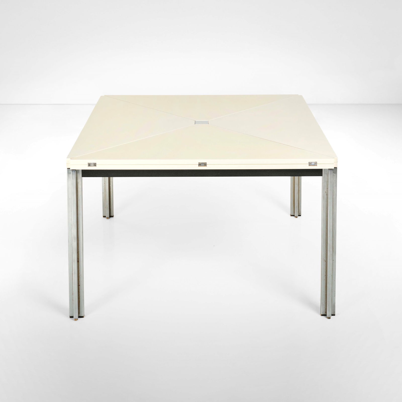 Eugenio Gerli Tavolo mod. T92: Struttura in metallo cromato e piano in legno laccato, con spicchi incernierati e richiudibili. Prod. Tecno, Italia, 1956. cm 148,5x148,5x h71,5 (aperto) 105x105x h74 (chiuso)