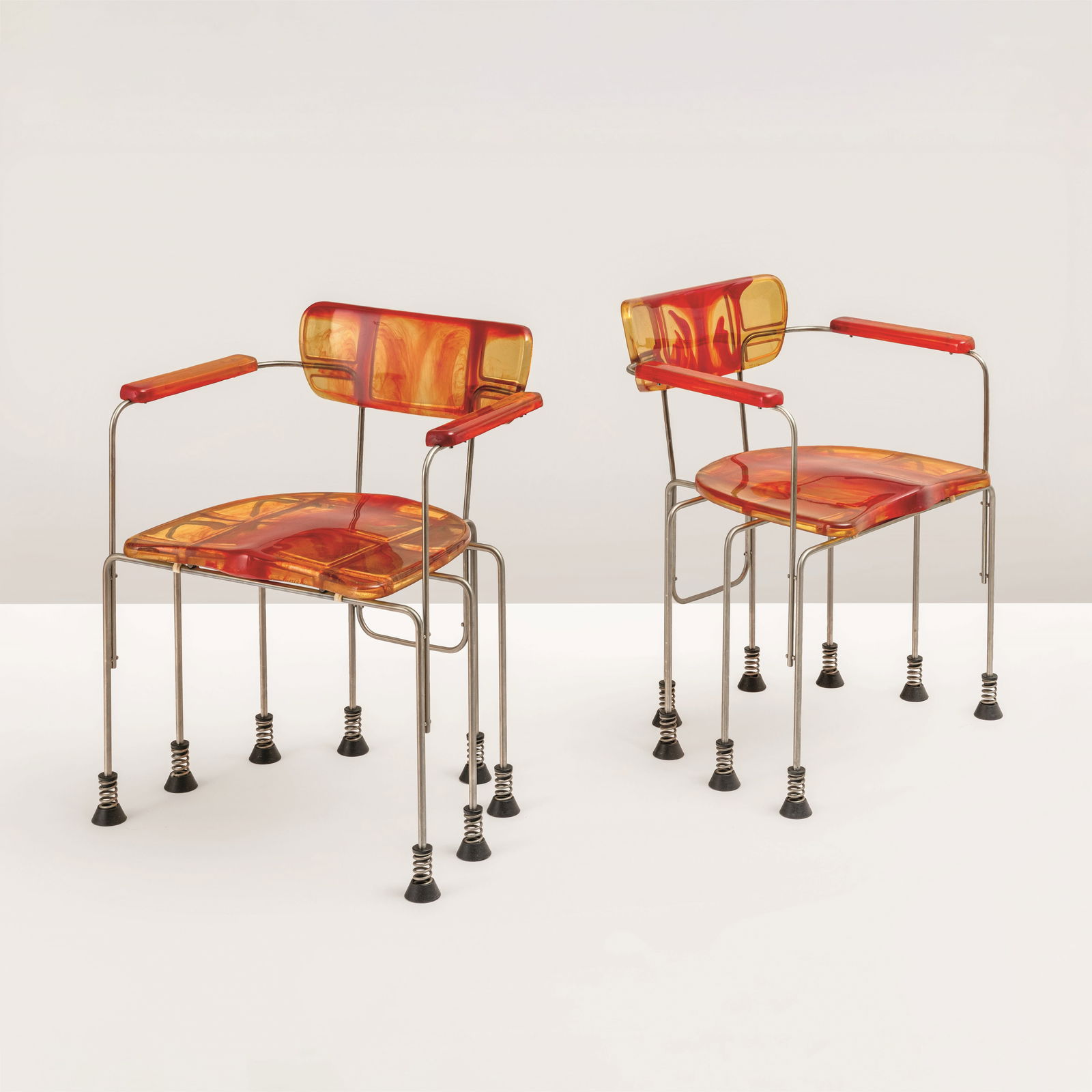 Gaetano Pesce Two mod. 544 Broadway armchairs.: Chromed steel structure with epoxy resin seat. Suspended feet on springs with rubber base. Bernini, Italy, 1993 Production catalogue.